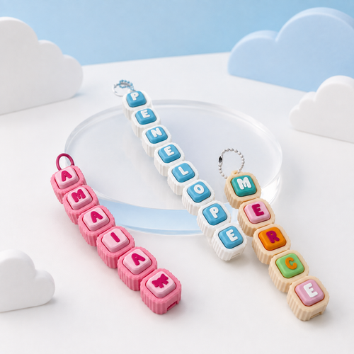 Three completed personalized Modular Keyboard Clicker chains displayed on a pastel blue and white cloud-themed background