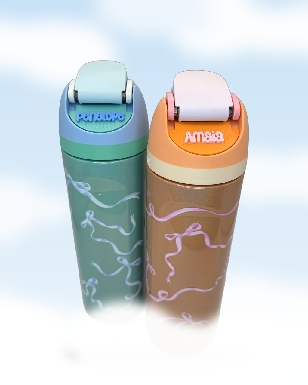 Penelope and Amaia personalized name plates on two Owala bottles, pastel cloud background